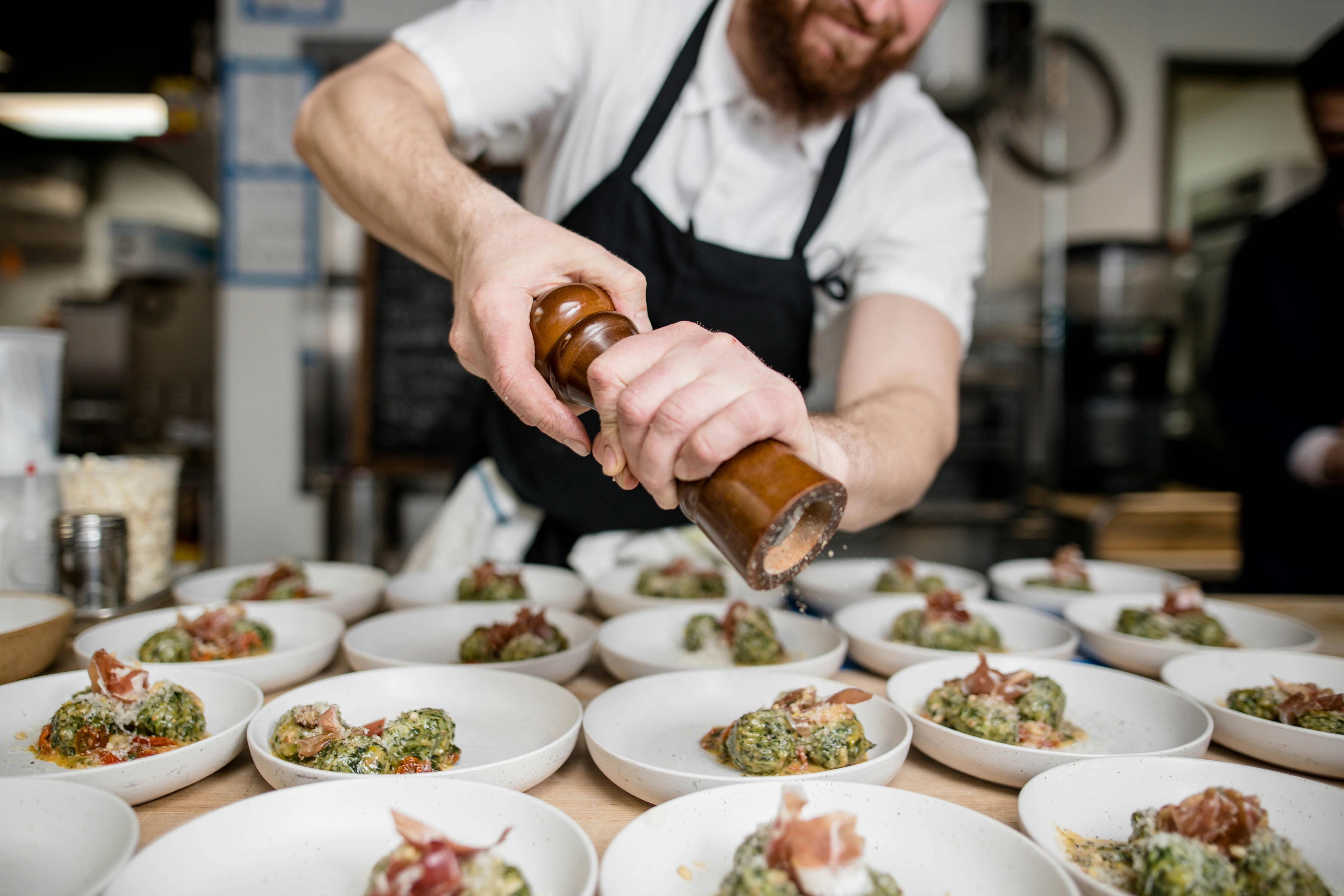 a chef seasoning dishes