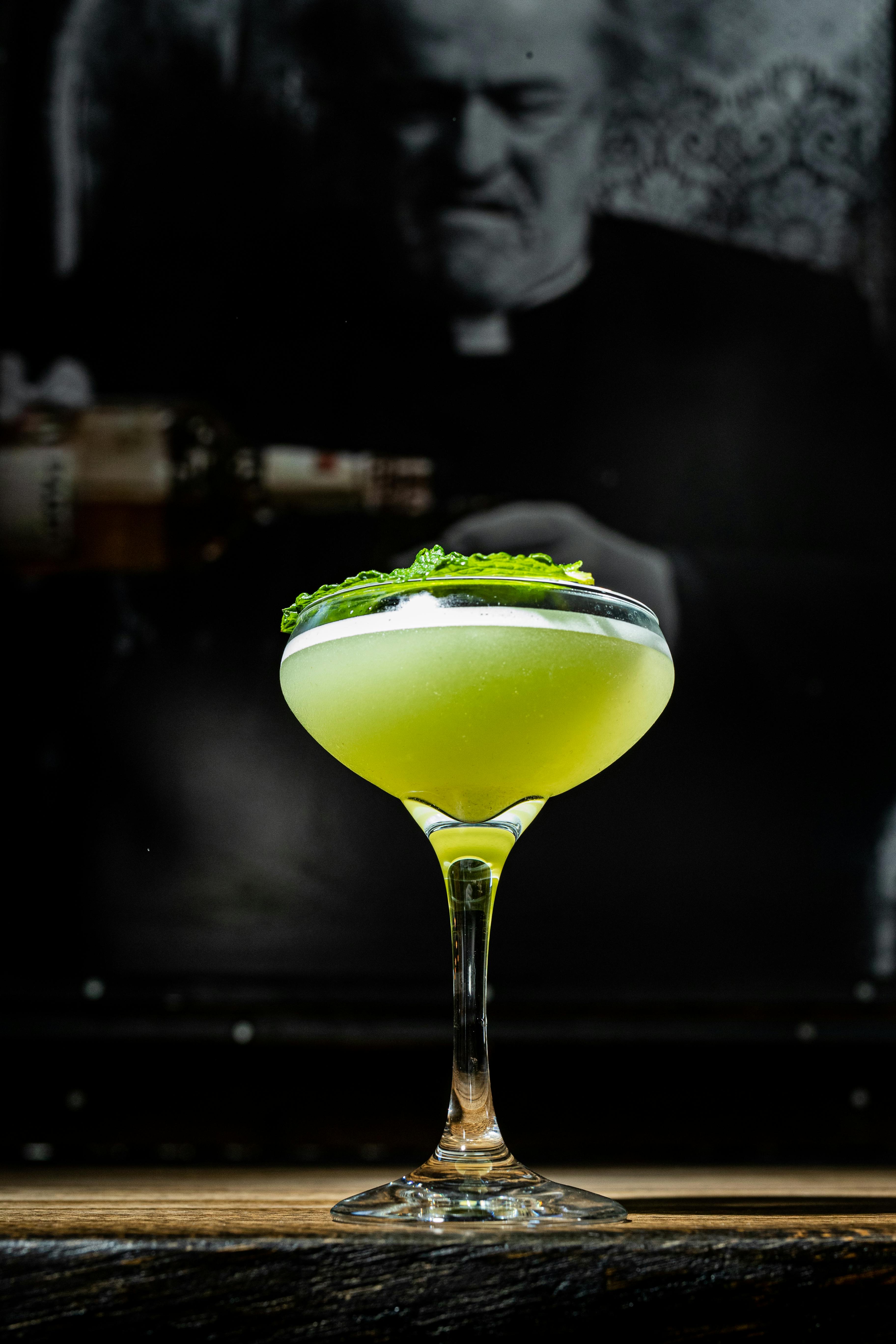 Elegant green cocktail in a glass with a mint garnish, perfect for bar menu design.