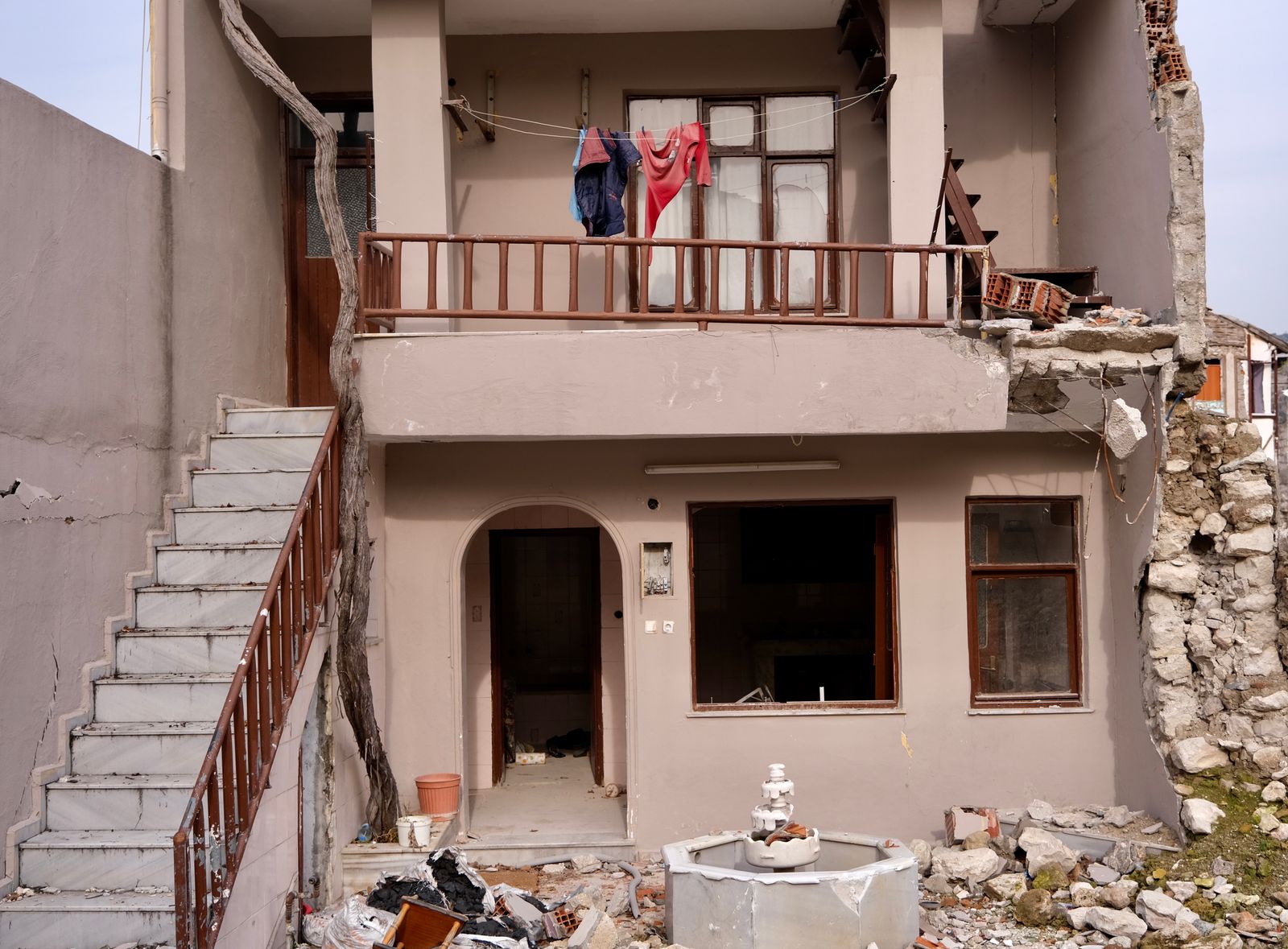 Damaged residential building facade with cracks and rubble