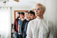 五名成年人在明亮的室内房间里摆姿势，展示当代眼镜时尚