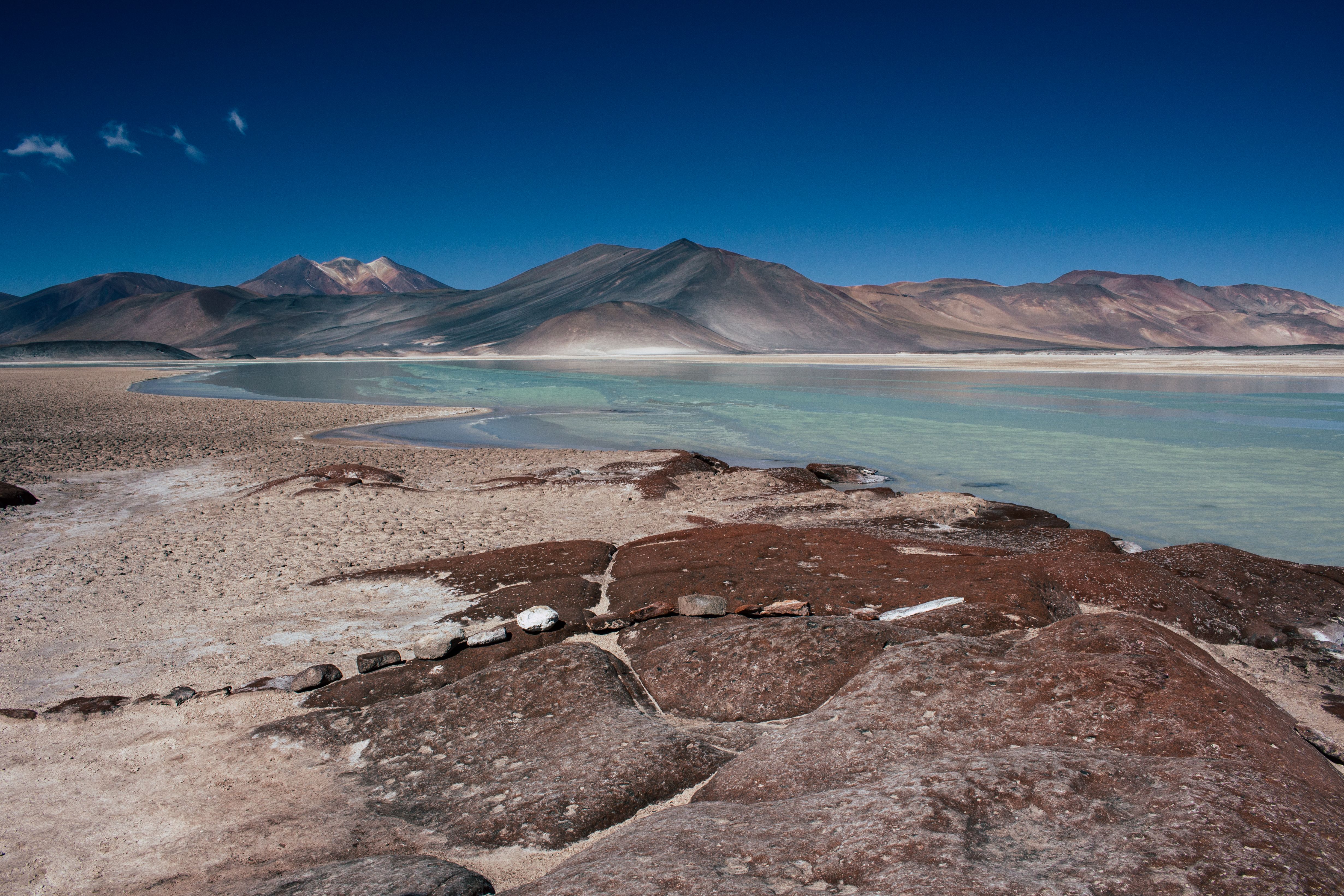 Breathtaking view of Atacama Desert's salt flats with majestic mountains in the background. Breathtaking view of Atacama Desert's salt flats with majestic mountains in the background.