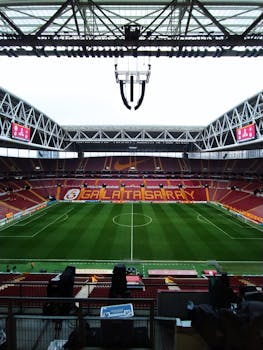 Empty Galatasaray football stadium with green field and empty seats in İstanbul, Türkiye.