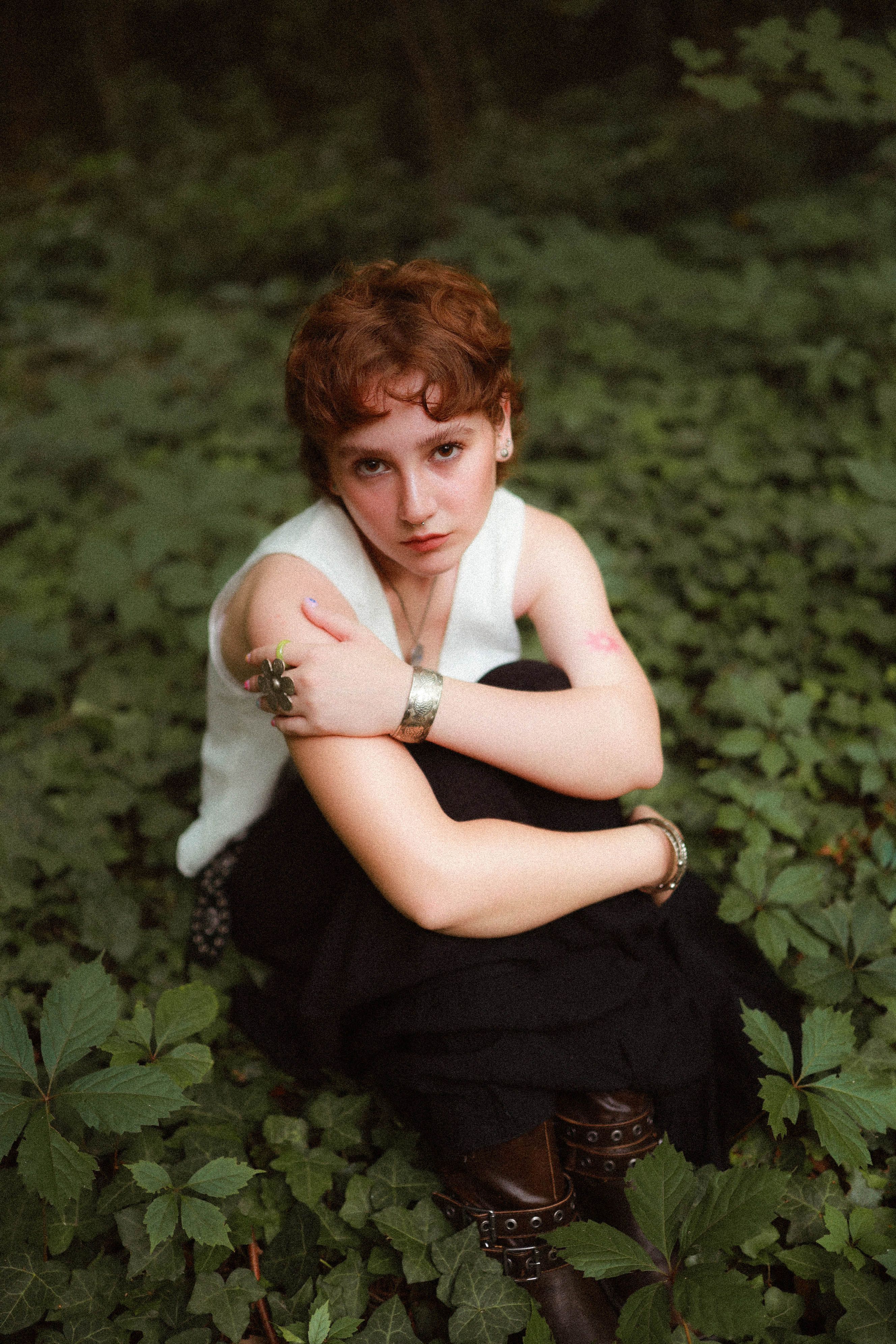 A Young Woman Sitting on the Ground with Green Plants in a Forest ...