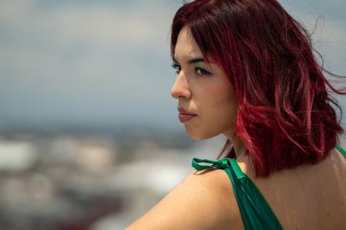 Free Stylish woman with red hair and green dress posing outdoors in Mexico City. Stock Photo