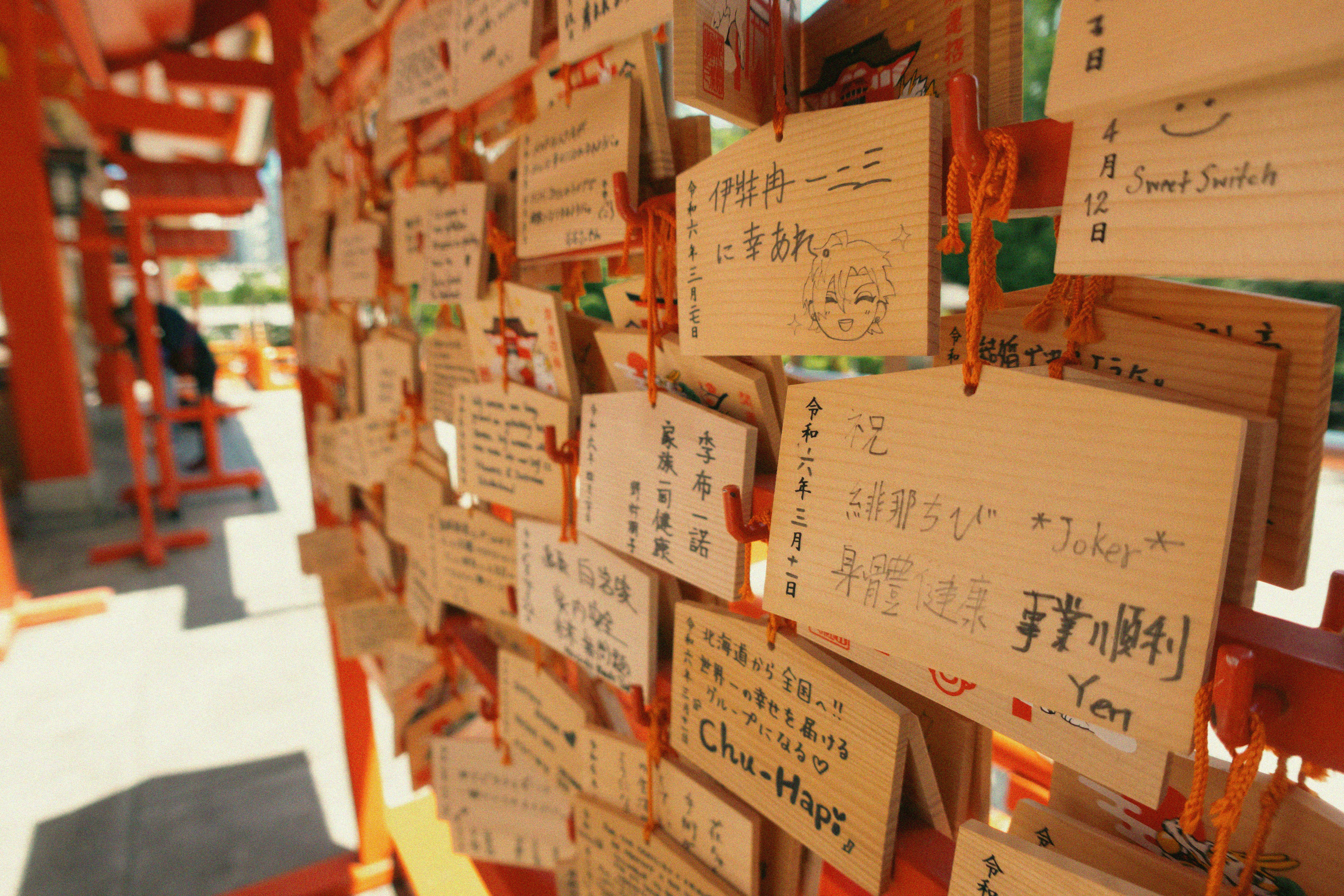 Close-up of Japanese Ema plaques hanging in a Shinto shrine, capturing a unique cultural tradition.
