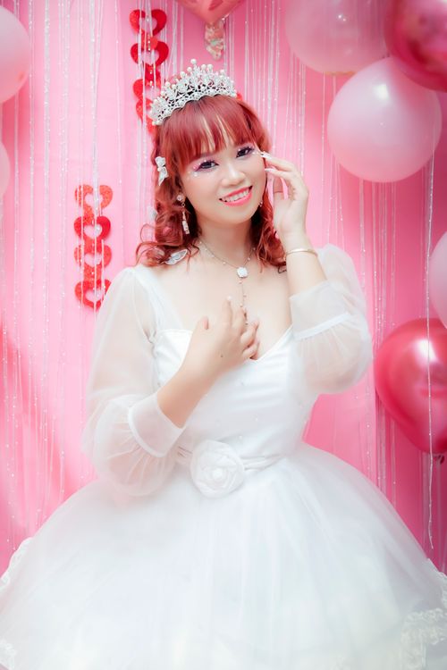 Free Happy bride in white dress and tiara with pink decorations and balloons. Stock Photo