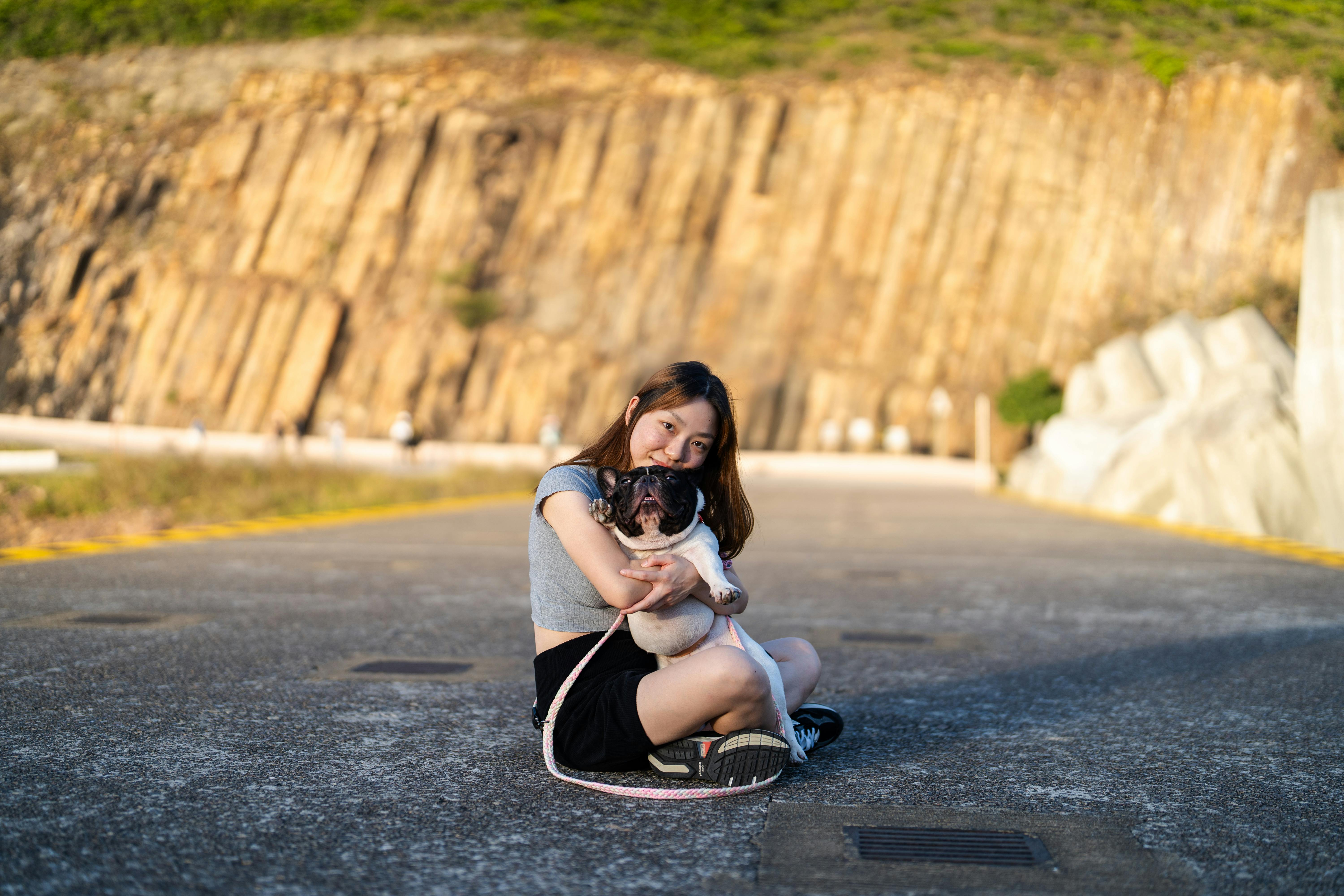 A woman sitting on the ground with a dog