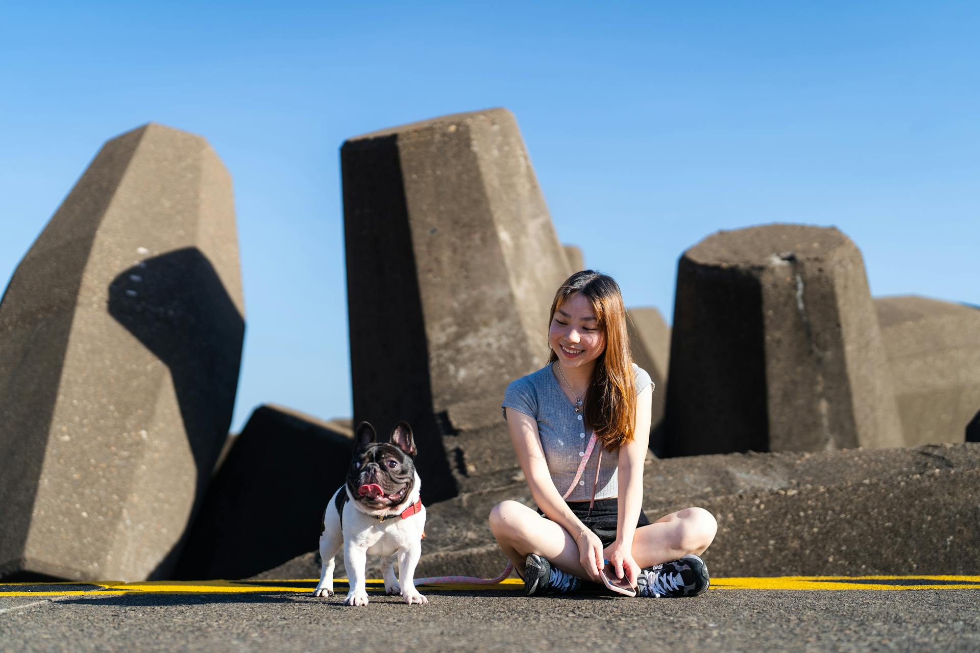 A Girl Sitting near Large Stones with Her Dog