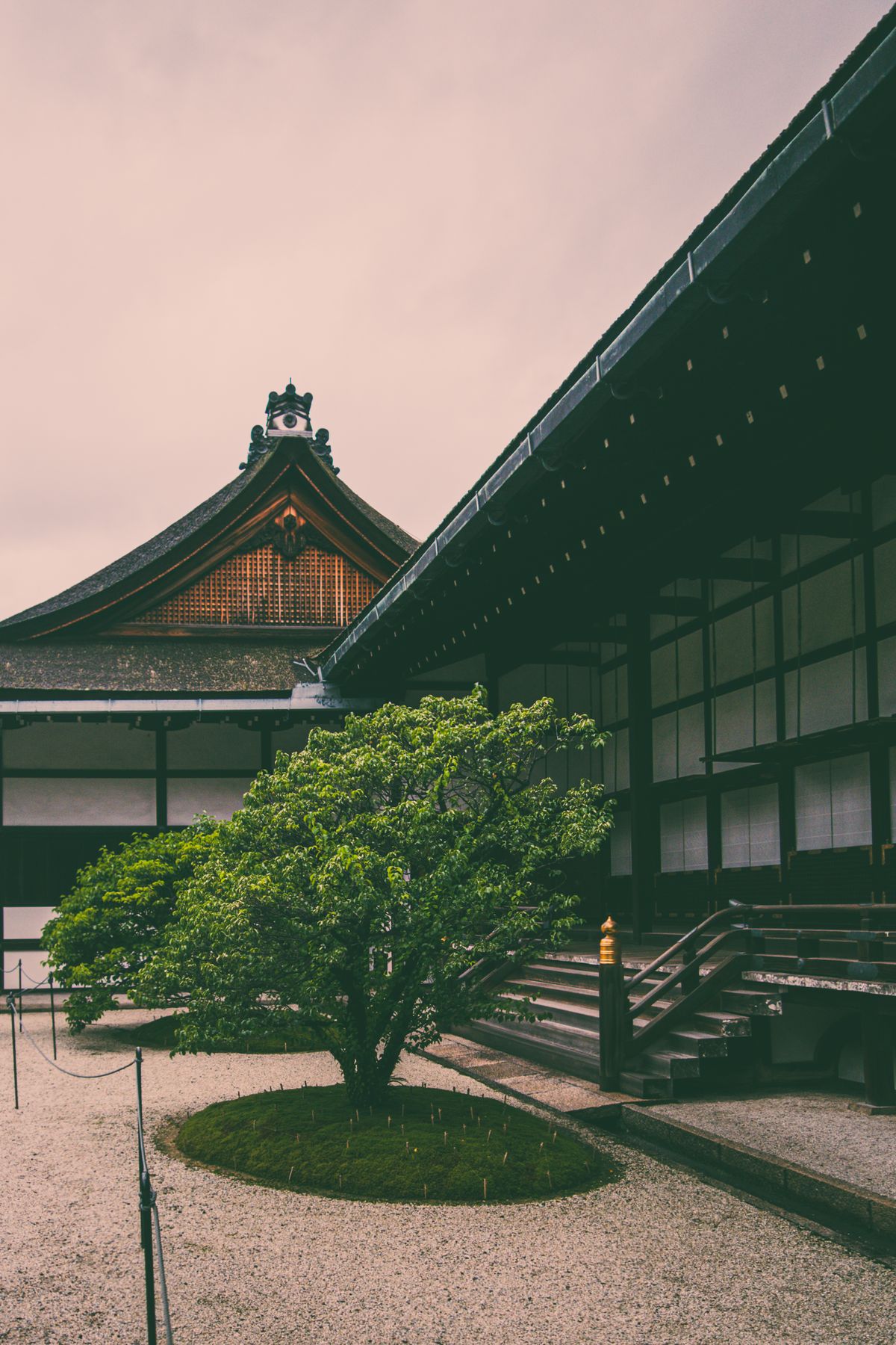 Traditional Japanese temple courtyard in Kyoto surrounded by greenery