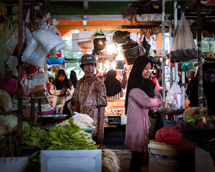 Bustling Indonesian market with people shopping for fresh produce.
