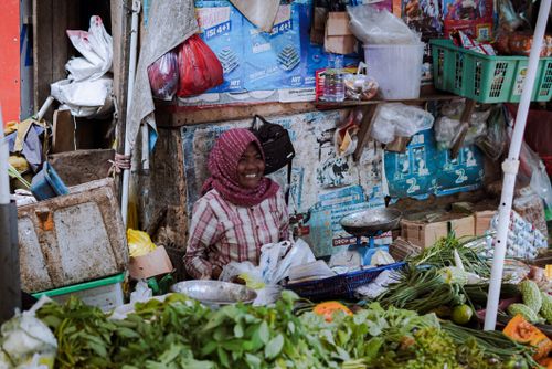 Free Smiling woman selling fresh produce at a market in Pontianak, Indonesia. Stock Photo