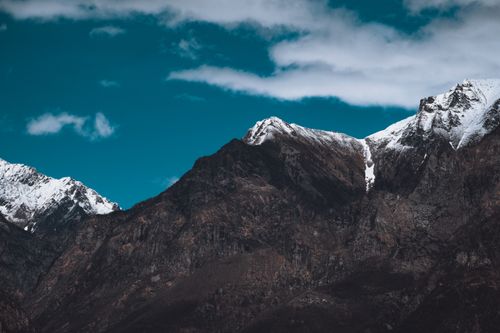 Free Breathtaking view of a snowcapped mountain range under a bright blue sky, perfect for travel inspiration. Stock Photo