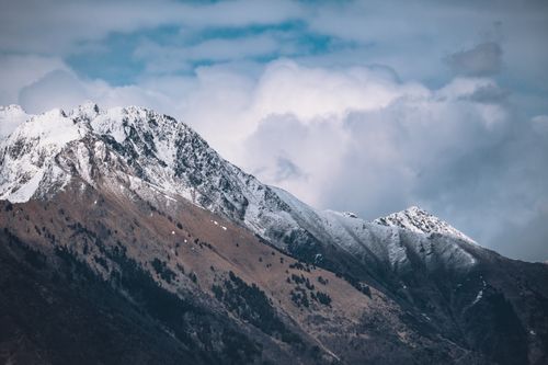 Free Stunning view of a snowcapped mountain against a dramatic cloudy sky, capturing the beauty of nature. Stock Photo