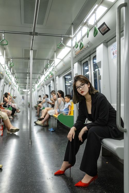 Free Young woman in stylish outfit sitting in subway showcasing modern urban fashion. Stock Photo