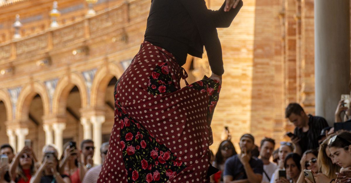 Seville 2026: Experience the Heart of Flamenco & History 12 An energetic flamenco dancer captivates a crowd at Spain's iconic Plaza de España in Seville.