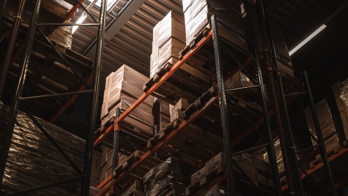 Depósito industrial con estanterías cargadas de cajas e insumos