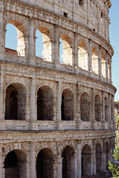 Free Close-up view of the Colosseum's sunlit arches in Rome, Italy, showcasing ancient architecture. Stock Photo