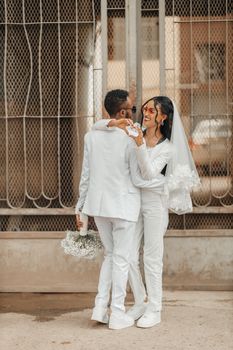 Happy bride and groom embracing outside, capturing a joyful wedding moment.