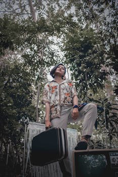 一位时尚女士手提行李箱，在郁郁葱葱的森林中摆出姿势，展现出冒险精神