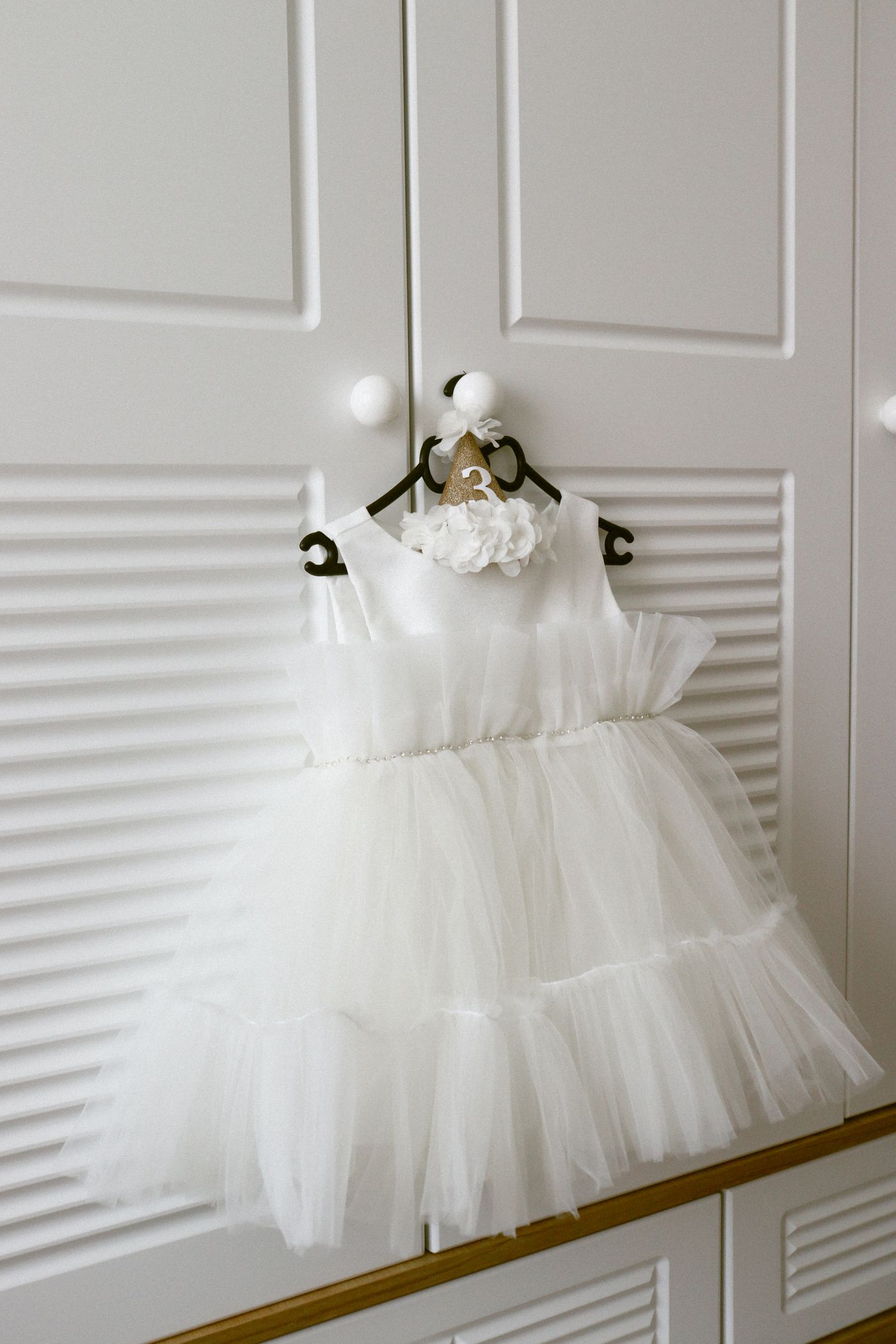 White tulle dress hanging on a closet door