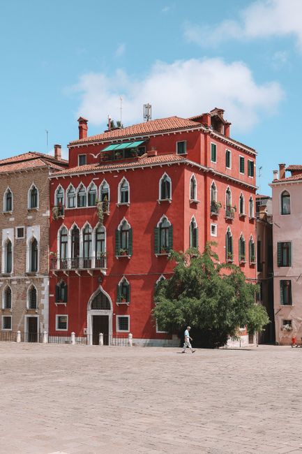 Picturesque red building with classic architecture in a sunny Florence square.