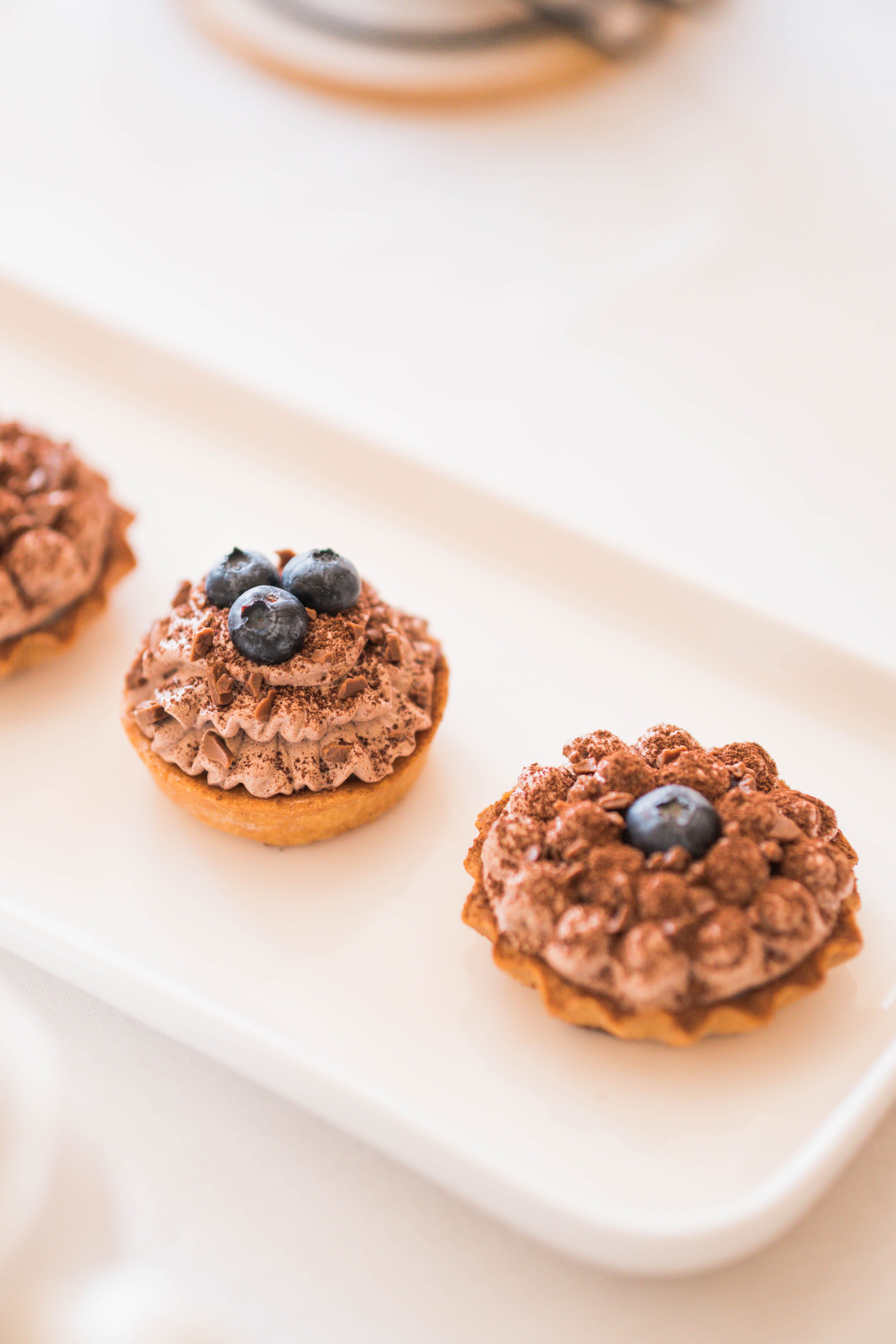 Close-up of chocolate cupcakes topped with fresh blueberries, perfect for dessert lovers.