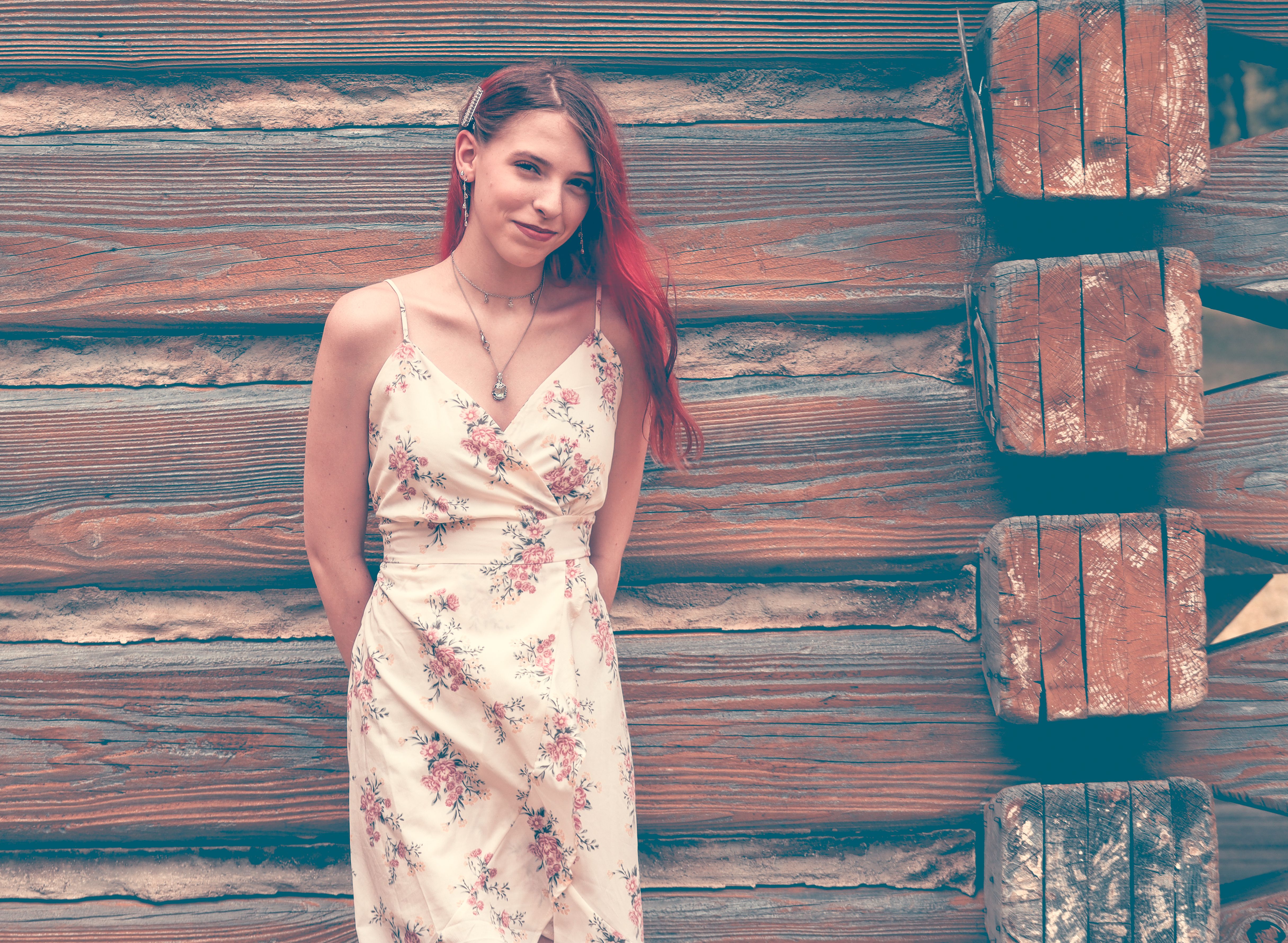 Young Woman in Floral Dress Posing by Wooden Wall · Free Stock Photo