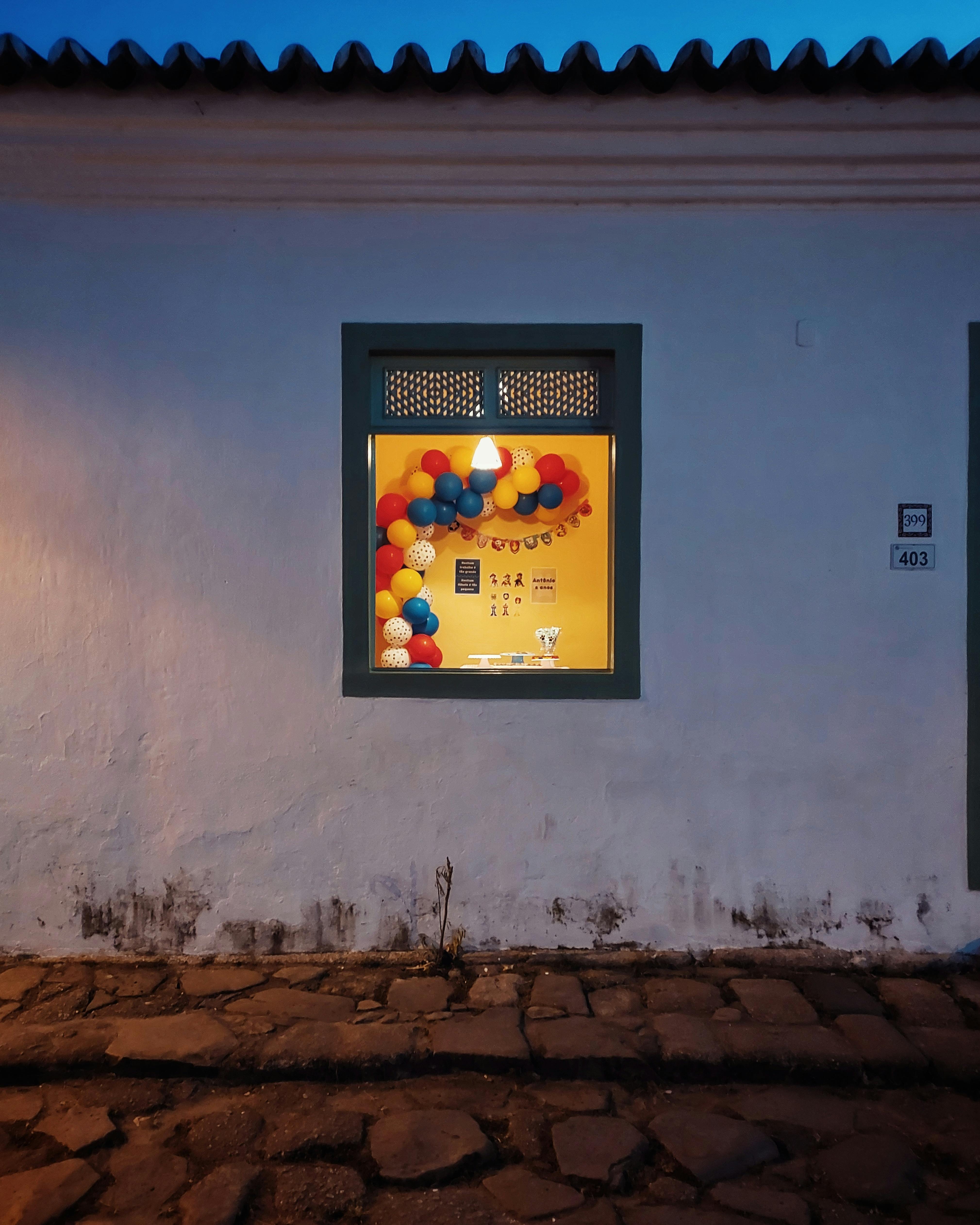 Vibrant birthday decorations seen through a window in Paraty, Brazil.