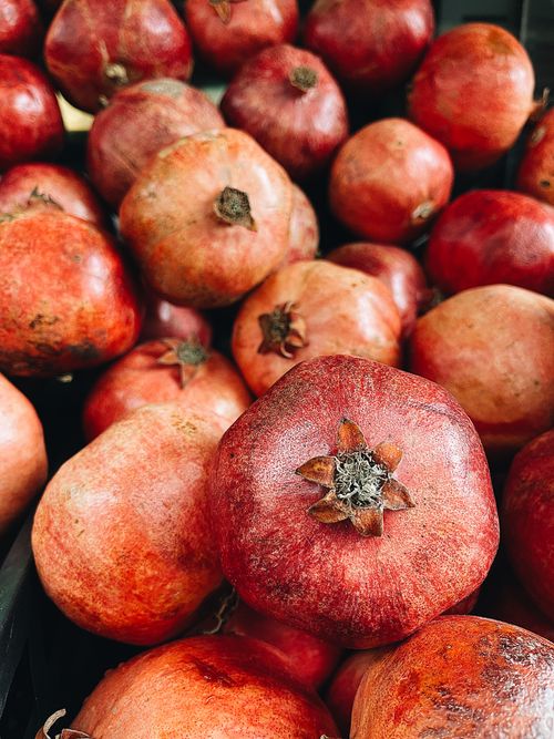 Free A heap of vibrant red pomegranates displayed, showcasing their natural texture and color. Stock Photo