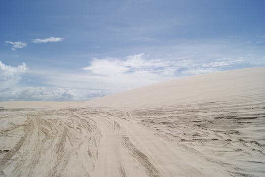 Explore the serene sand dunes of Jericoacoara, Brazil under a clear sky, perfect for adventure seekers.