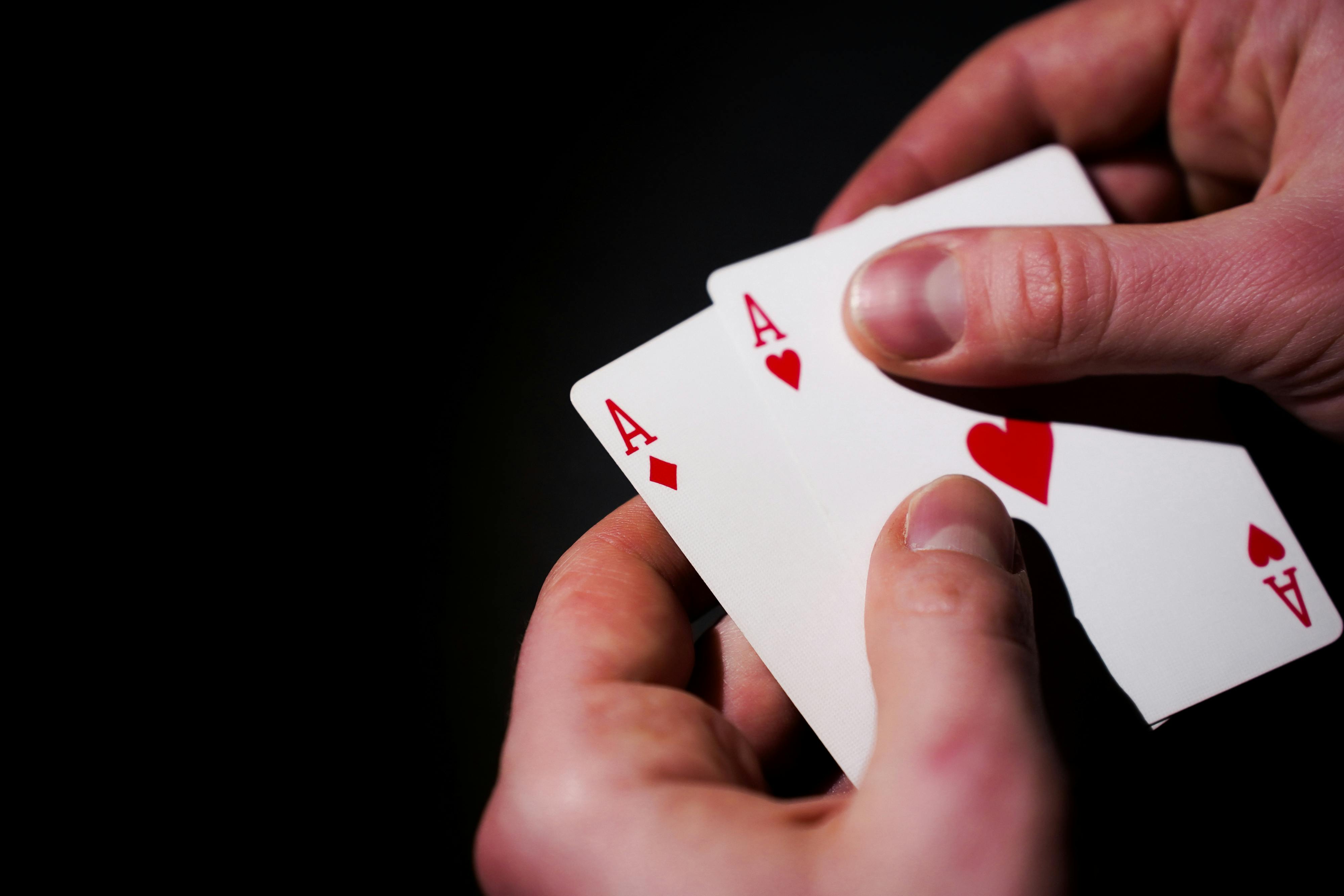 a person holding two playing cards in their hands