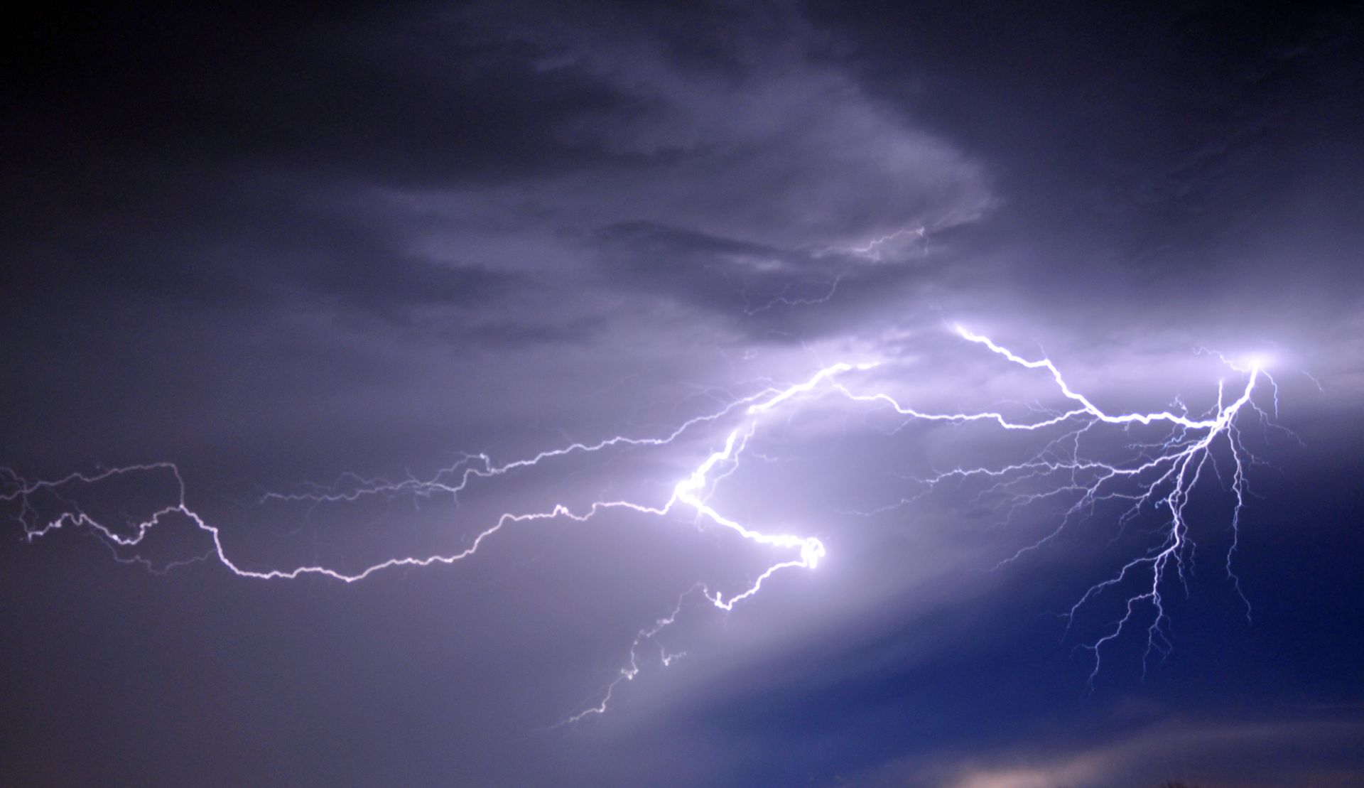 A striking image of bright lightning cutting through dark, stormy clouds at night.