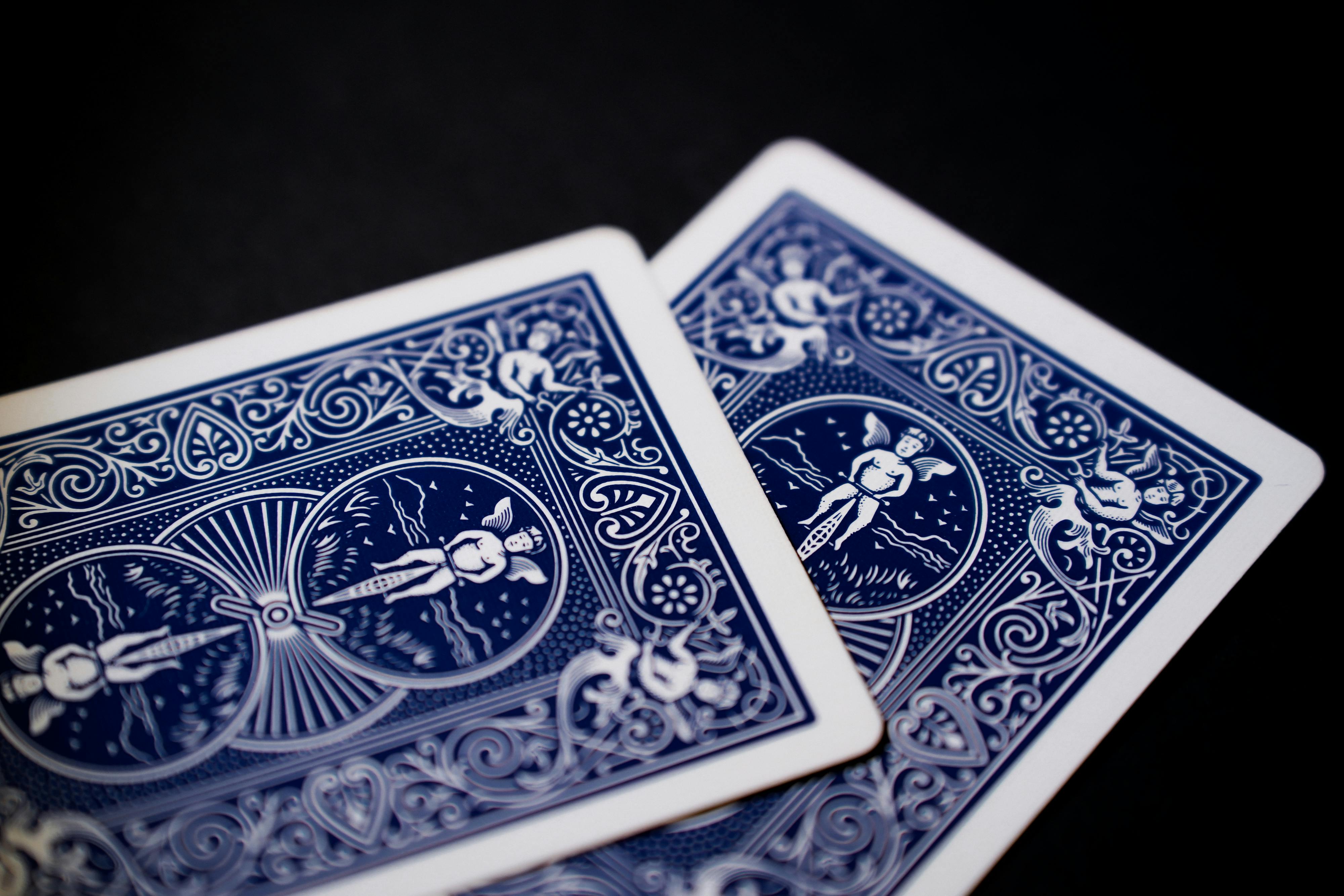 two blue playing cards with a white design