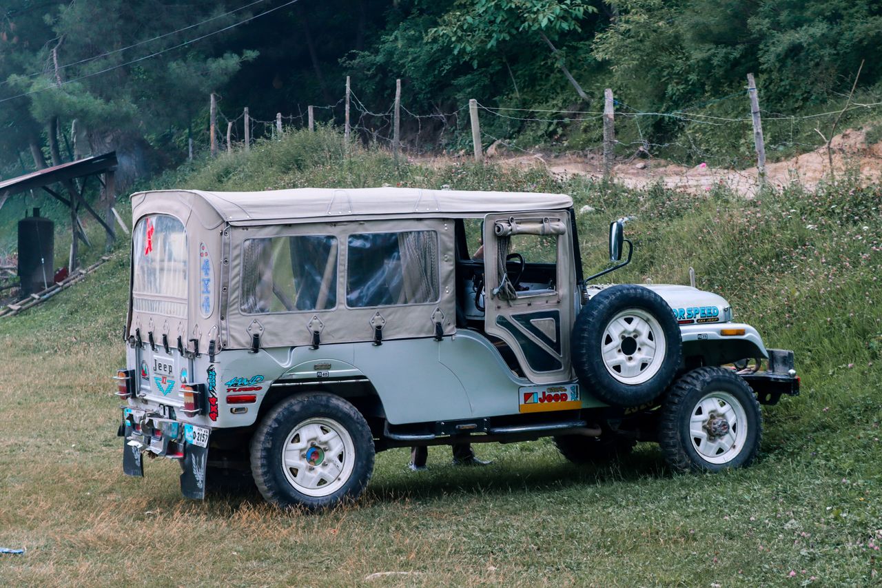 a rugged off road jeep parked in the scenic greenery of naran pakistan