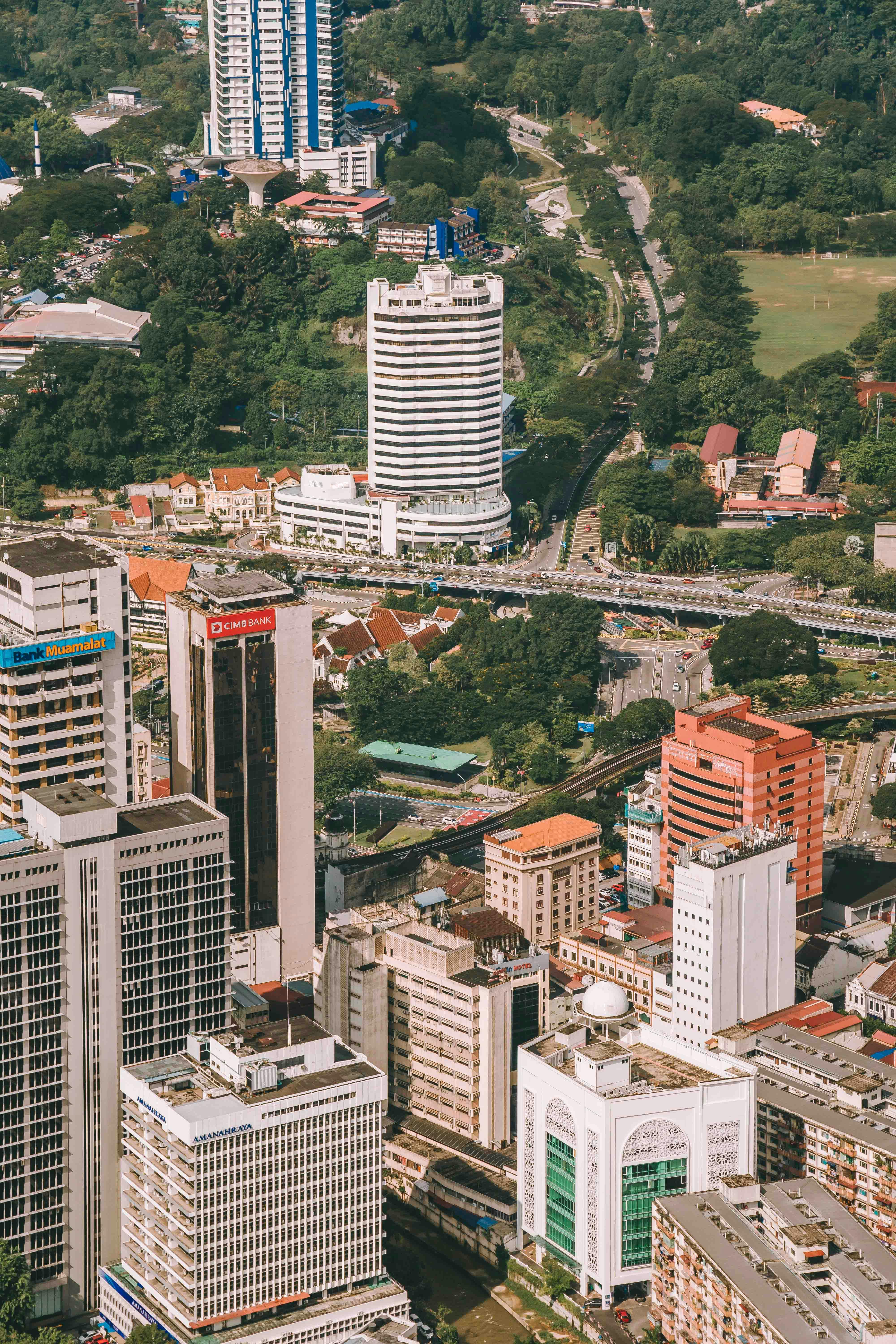 Aerial view of Kuala Lumpur's modern urban architecture and lush greenery.