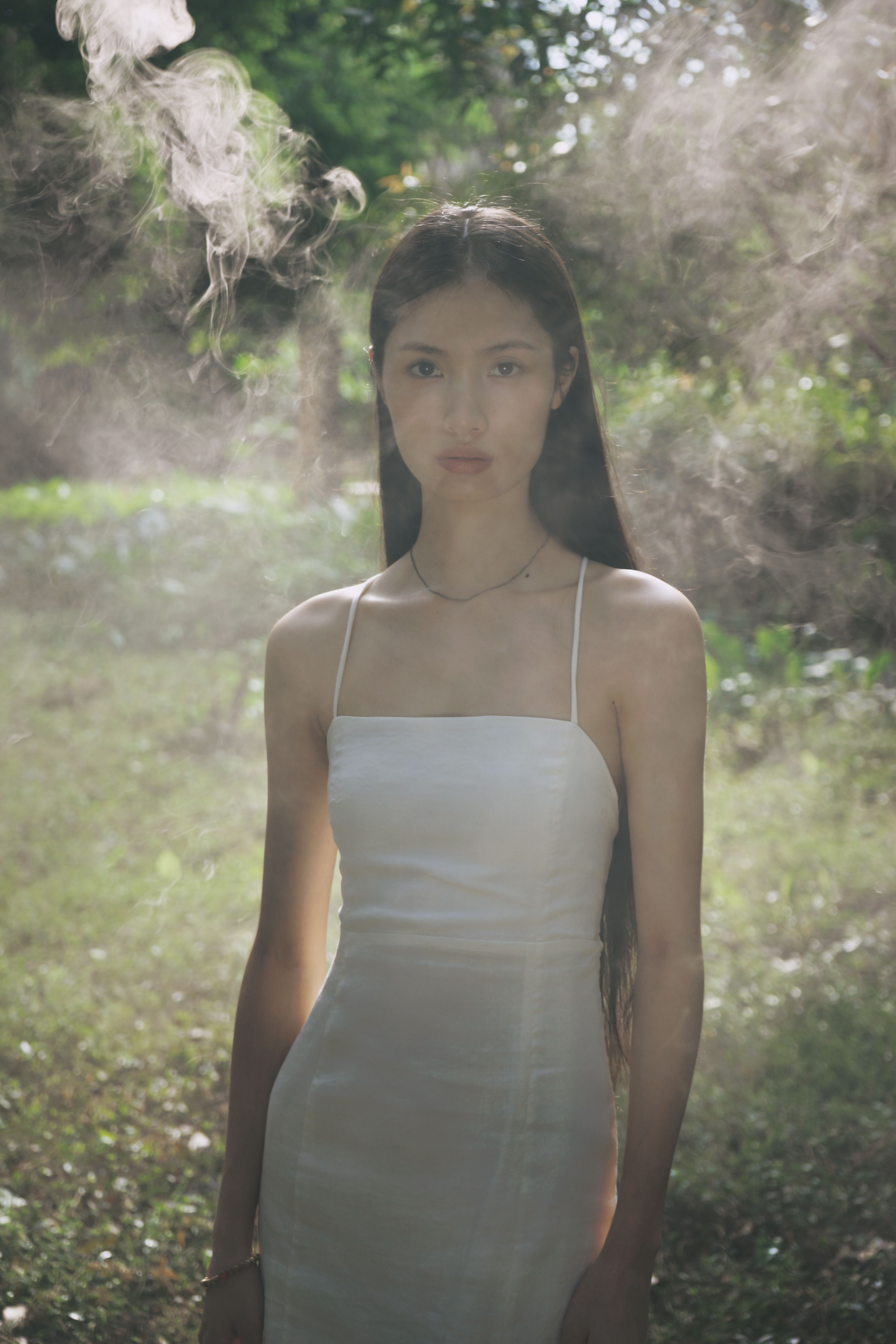 Model in a White Dress Standing in the Smoke · Free Stock Photo