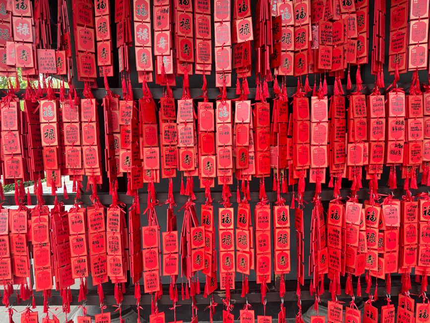 A colorful display of traditional red hanging tags used for wishes in Asian cultures.