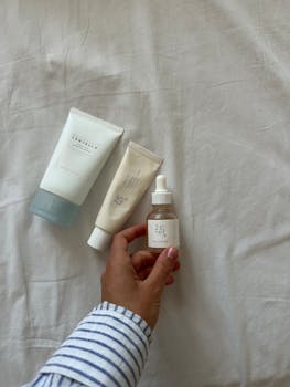 Flat lay of skincare products showcasing modern packaging on a neutral fabric background.