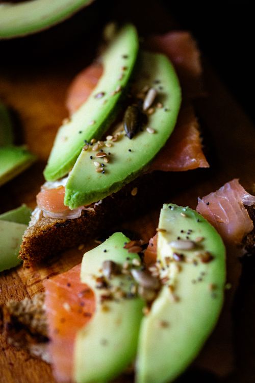 Free Close-up of avocado and smoked salmon toasts with seeds on rye bread. Stock Photo