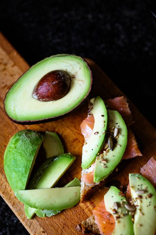 Free Top view of fresh avocado and smoked salmon on a wooden cutting board. Stock Photo