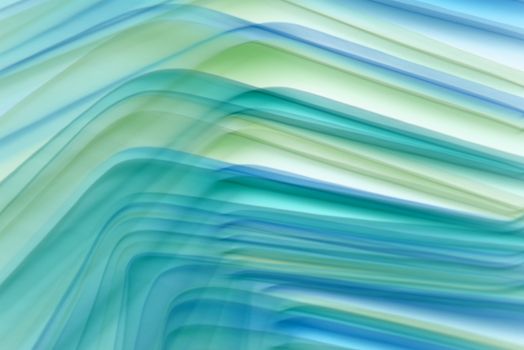 Abstract design featuring smooth, flowing waves in green and blue tones creating a dynamic visual texture.