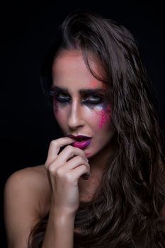 Close-up portrait of a woman with dramatic makeup and wet hair, showcasing artistic expression.