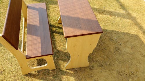 砂の上のベンチが付いている茶色の木製の机