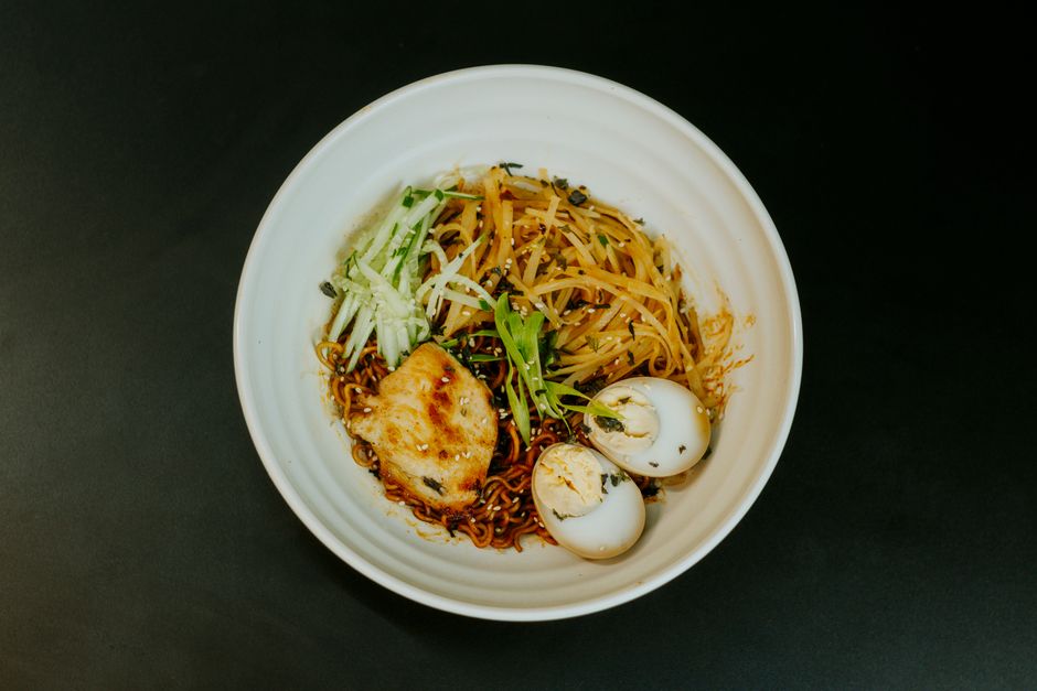 A top view of a delicious Asian noodle dish with chicken and two halves of boiled eggs.