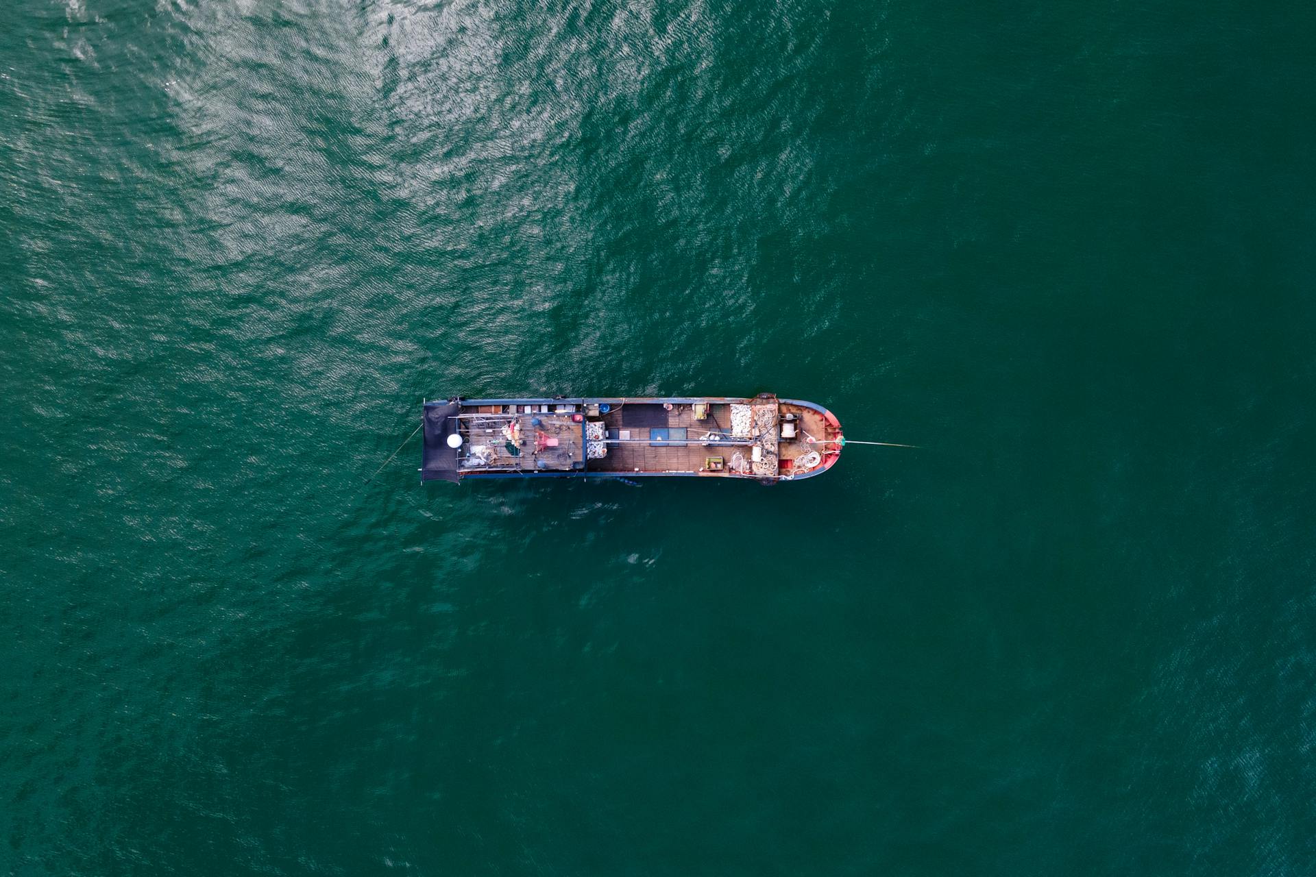 Aerial shot of a cargo ship sailing in Shantou, China, showcasing maritime transportation.