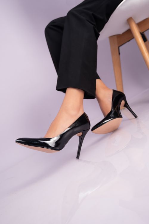 Free Stylish high heels on a woman's legs sitting on a chair in a studio setting. Stock Photo