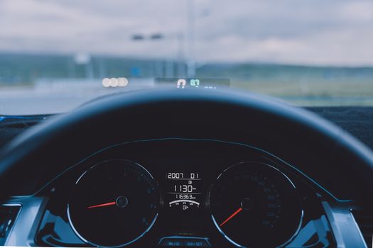 View from inside a car showing dashboard and steering wheel on an open road.