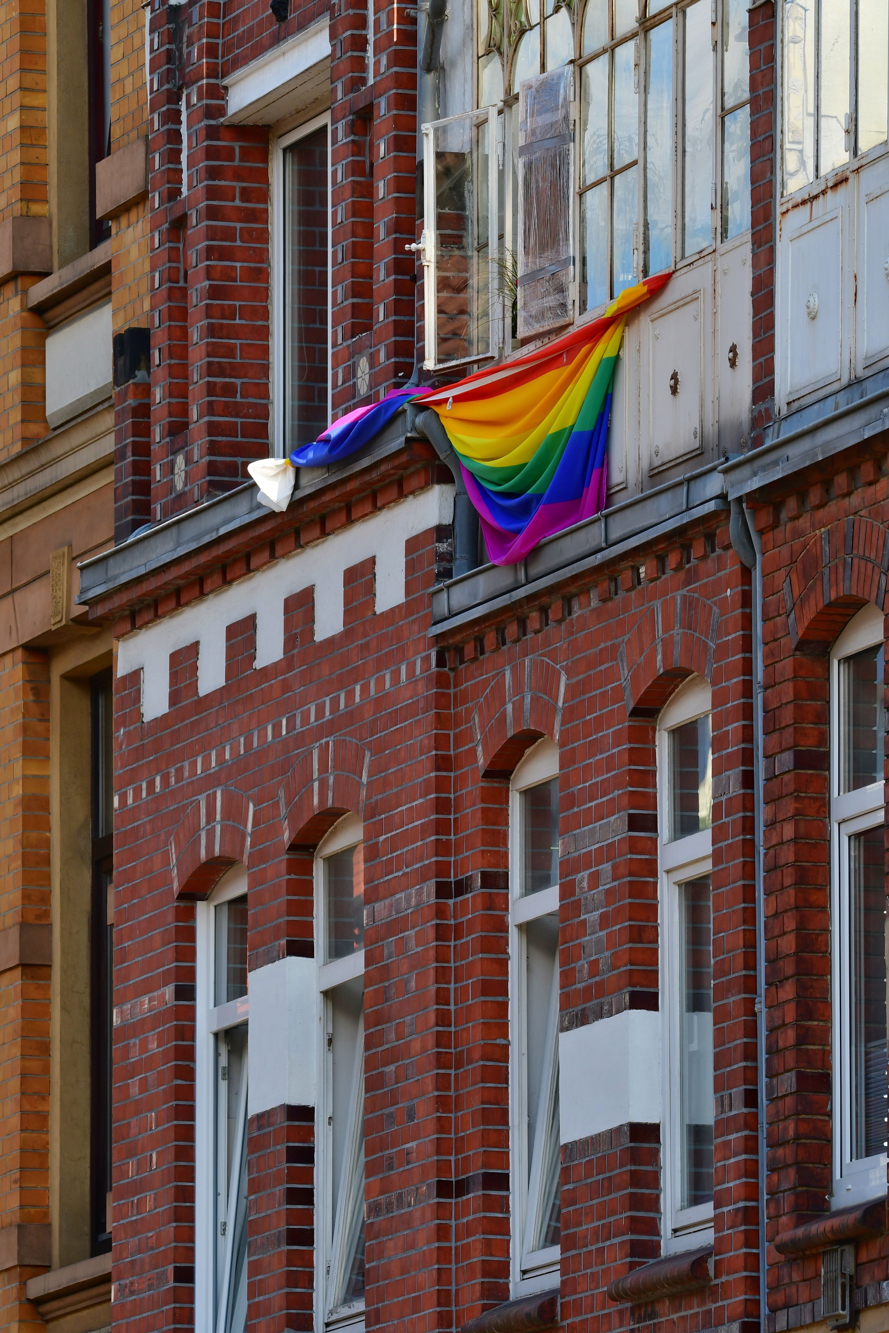A Rainbow Flag Hanging Outside of a Building · Free Stock Photo