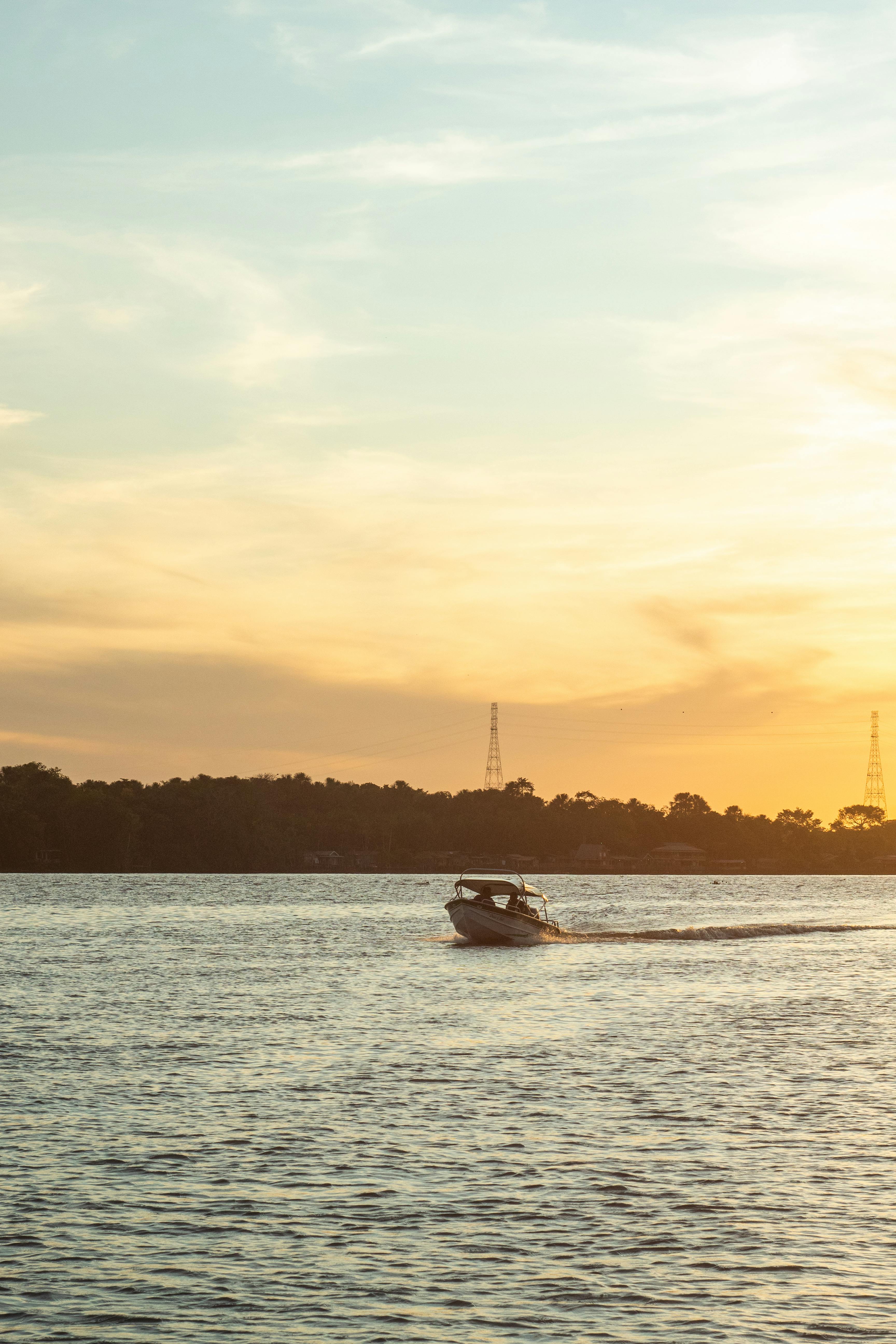 a boat is traveling on the water at sunset