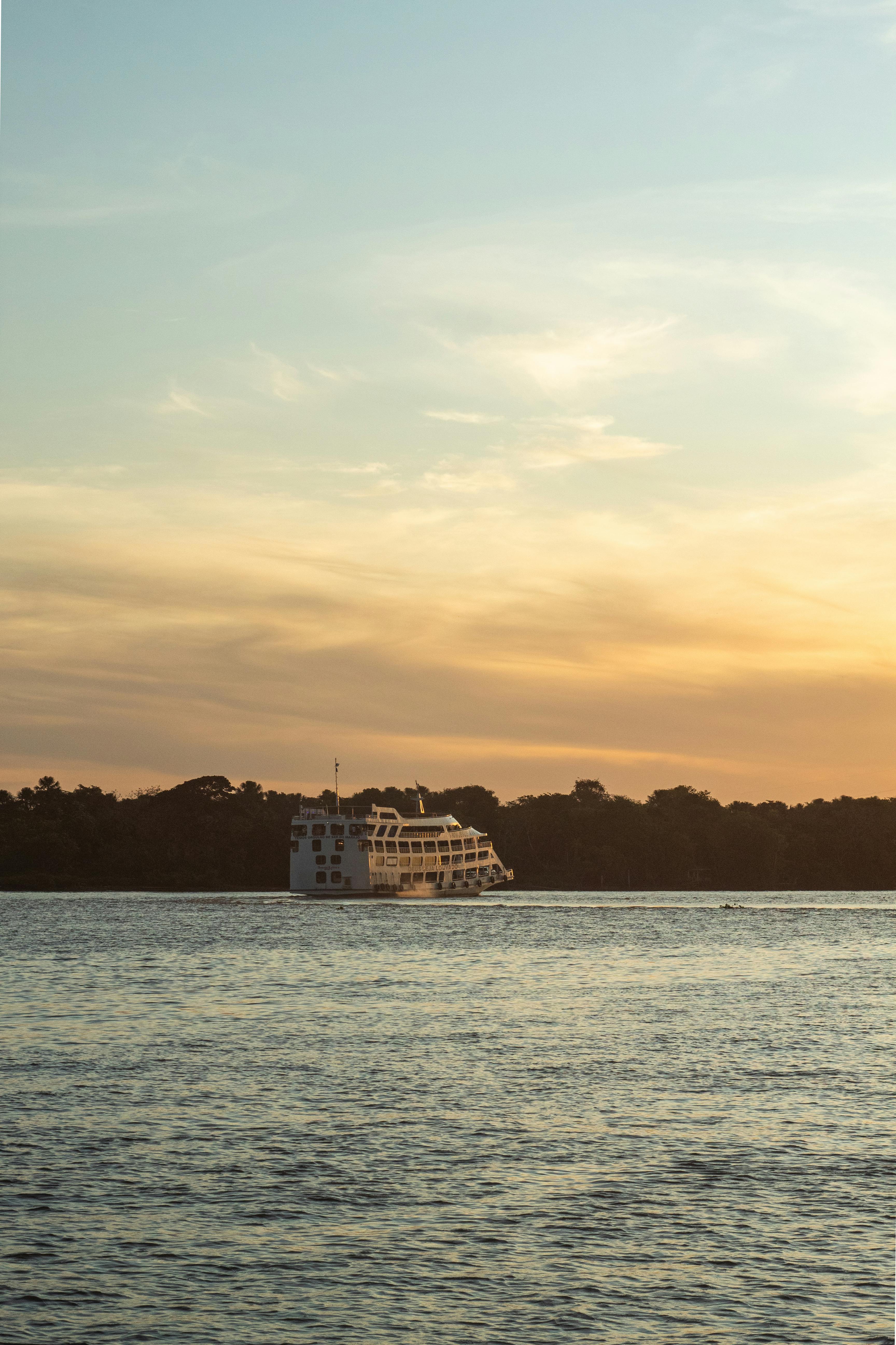 passenger ship on sea coast at sunset